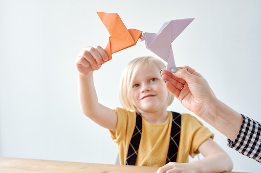 Foto: Mädchen bastelt Origami-Vogel